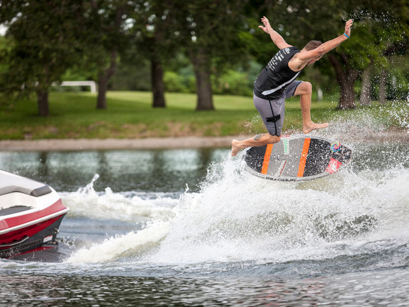 A man competing in a wakeboarding contest, skillfully riding his wakeboard in the water.