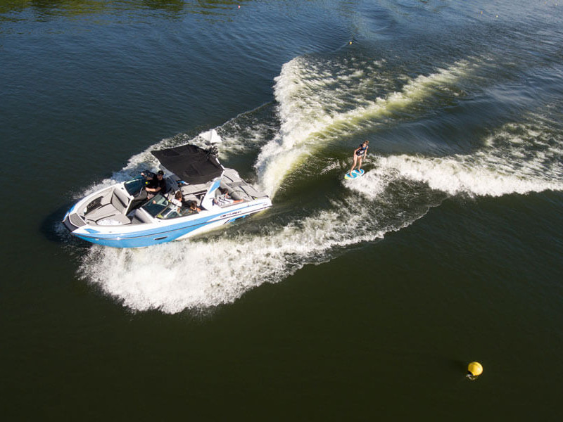 A man is competing on a water ski with competitors.
