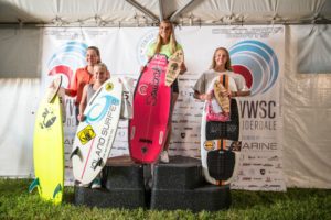 A group of surfers standing on top of a podium with surfboards.