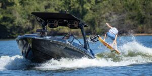 A **contest competitor** is **wake surfing** on a boat.