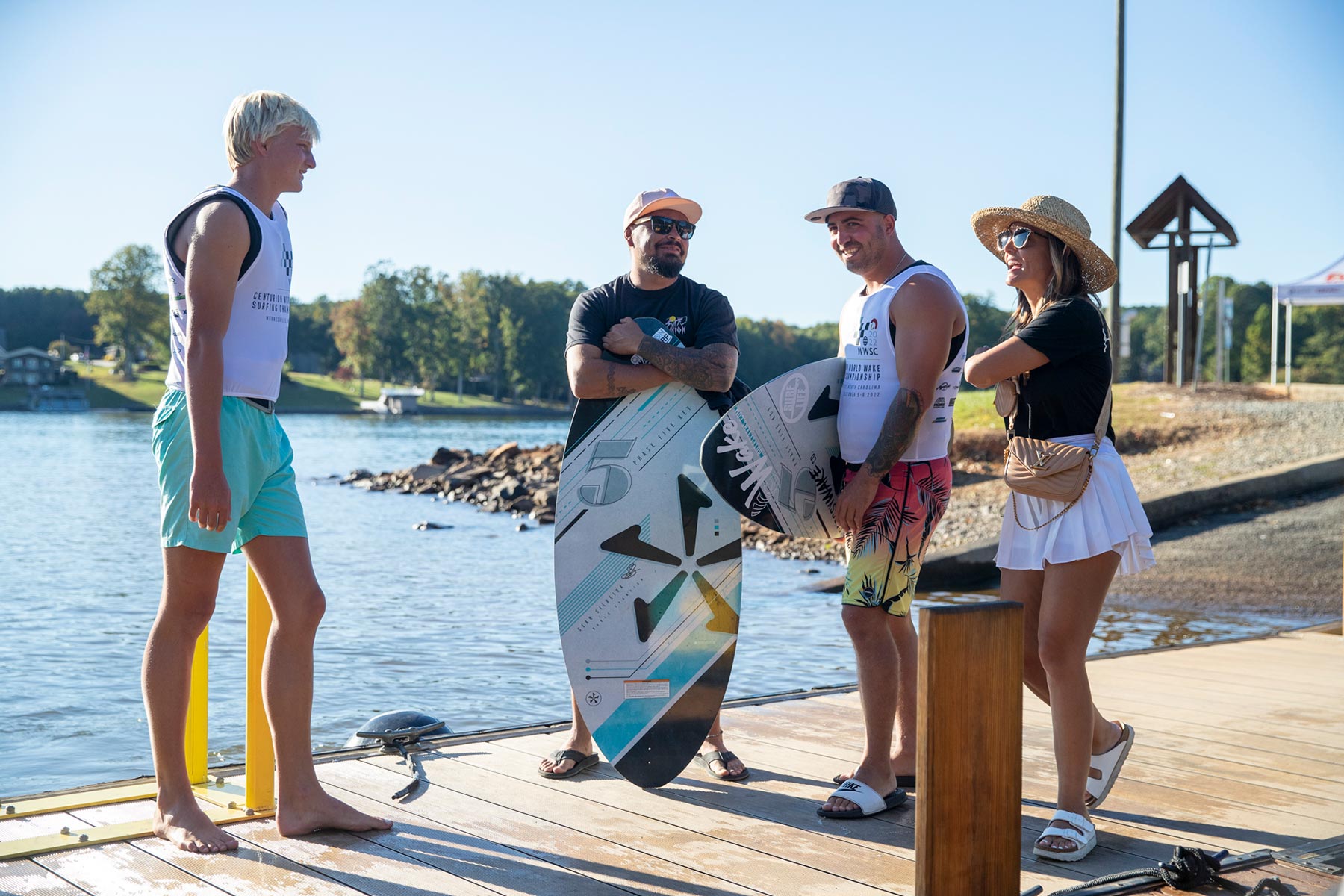 A group of surfers standing on a dock in a surfing contest.