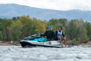 Two competitors riding a jet ski in a lake contest.