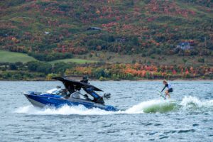 A person is riding a jet ski on a lake, participating in a competition for fans.
