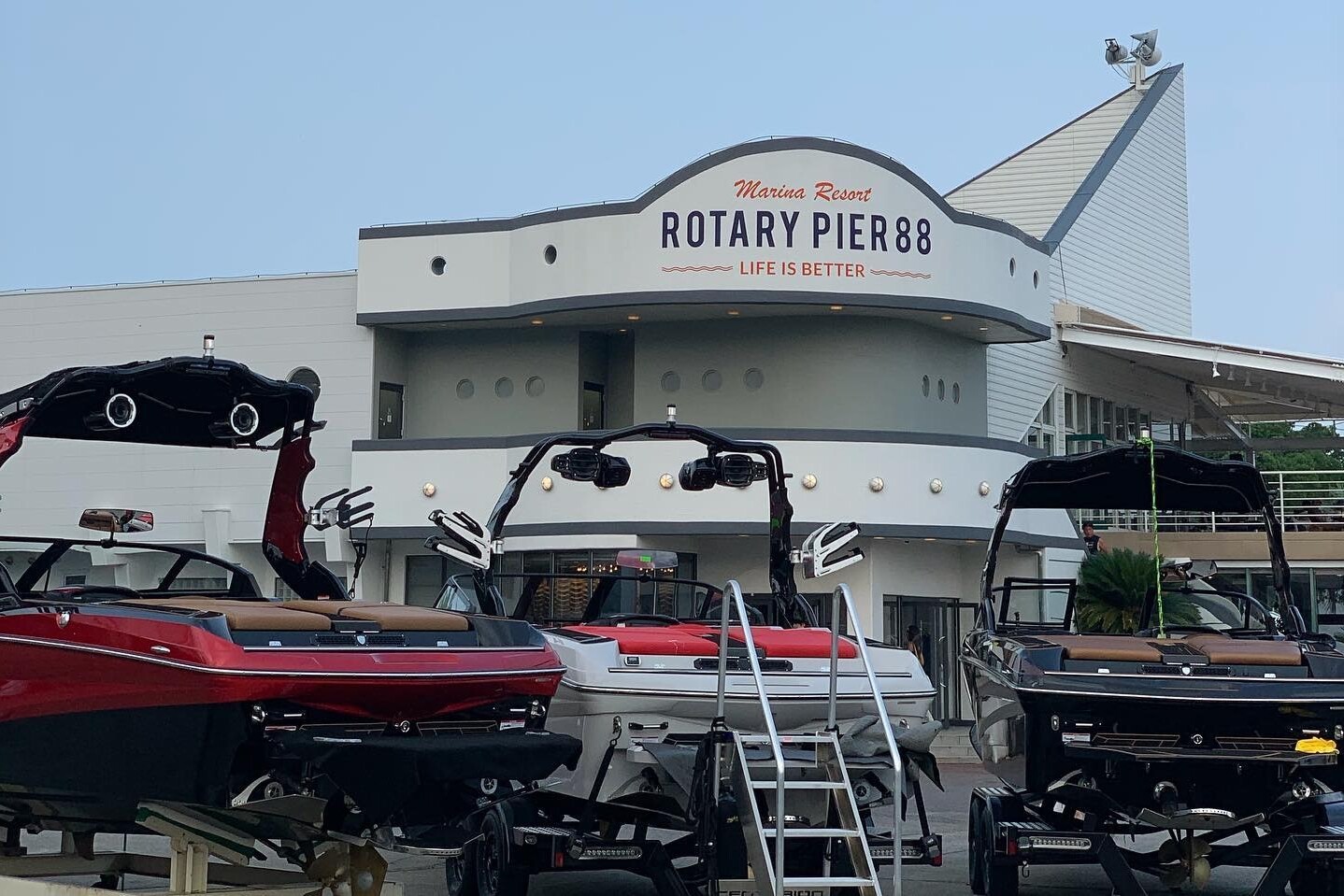 Several boats are docked in front of Rotary Pier 88 at Marina Resort, with a sign that reads 