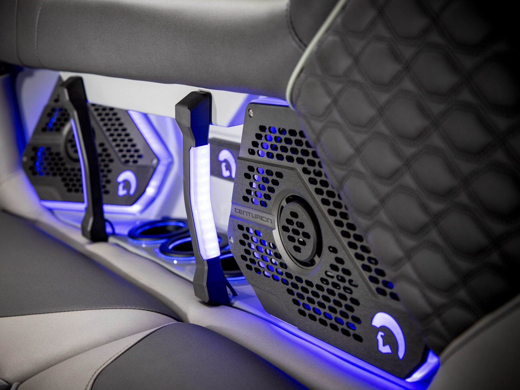 Close-up of black and gray quilted seats with built-in Centurion speakers and blue LED accent lighting, showcasing the refined craftsmanship found in The Centurion Ri Series.